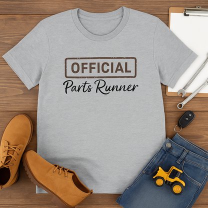 Gray t-shirt with 'OFFICIAL Parts Runner' text on a wooden surface with shoes and jeans.