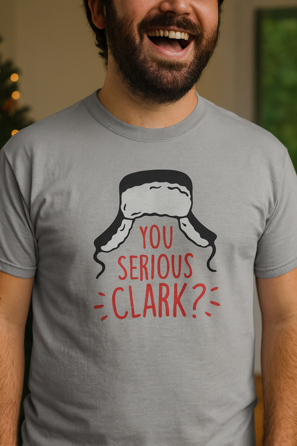 Person wearing a gray t-shirt with a Christmas-themed graphic and text.